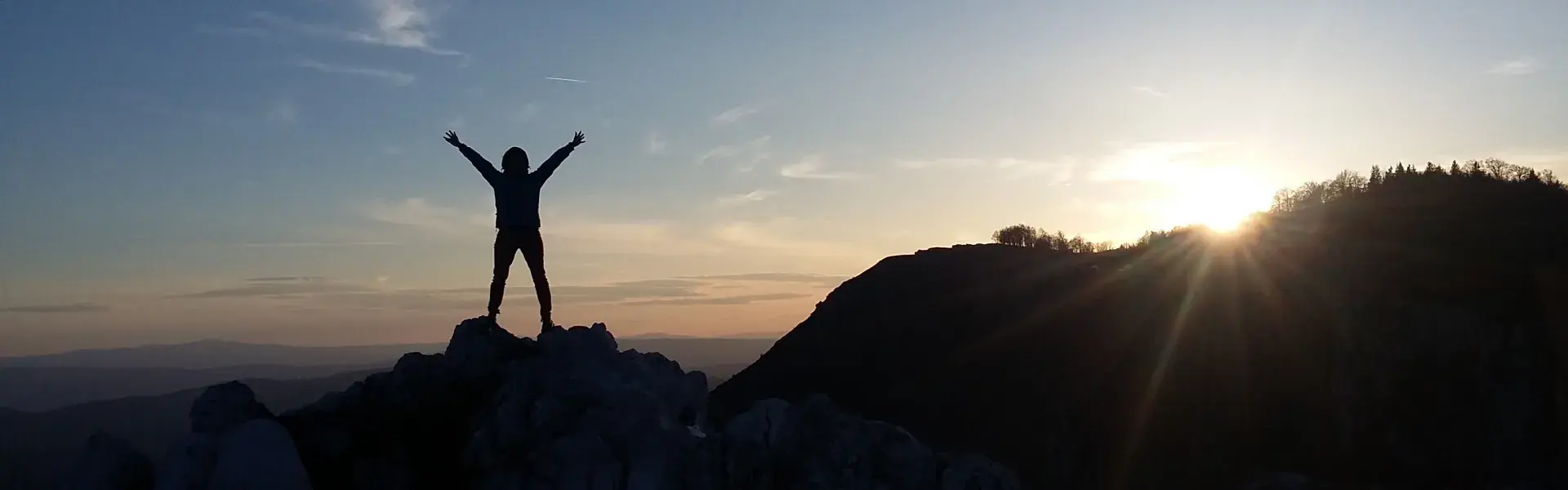 Sonnenuntergang mit Schatten von einer Person auf einem Berggipfel